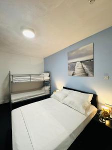 ein Schlafzimmer mit einem weißen Bett und Etagenbetten in der Unterkunft Hotel Vibes in Blackpool + 33 Fotos