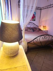 a lamp sitting on a table next to a bed at Casa Lugori in Torre Dei Corsari +13 photos