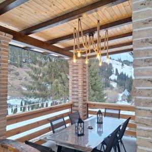 a patio with a table and chairs on a deck at Cabana Edav in Ţibău