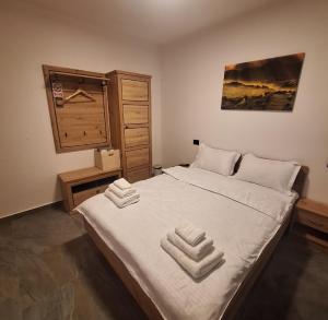 a bedroom with a large bed with two towels on it at Cabana Edav in Ţibău