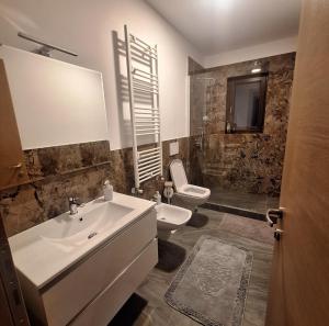 a white bathroom with a sink and a toilet at Cabana Edav in Ţibău +28 photos