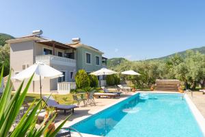 a villa with a swimming pool and a house at Golden Sun Villas in Nydri