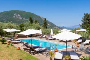 a swimming pool with chairs and umbrellas at Golden Sun Villas in Nydri