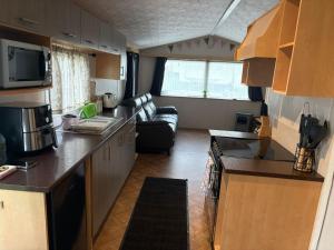 a kitchen and living room of a caravan at Miranda and Pauls Caravan in Leysdown-on-Sea