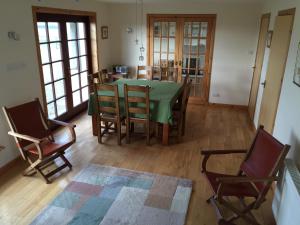 a dining room with a green table and chairs at Holiday Home Croft46 in Clachan