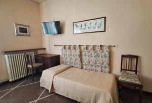 a bedroom with a bed and a chair and a tv at Red Horse in Pisa