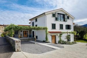 a white house with ivy on the side of it at Private Villa for 12 Peaceful Karst Escape in Dutovlje
