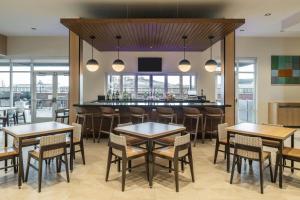 a restaurant with tables and chairs and a bar at TownePlace Suites by Marriott Canfield in Canfield