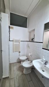 a white bathroom with a toilet and a sink at Red Horse in Pisa +9 photos