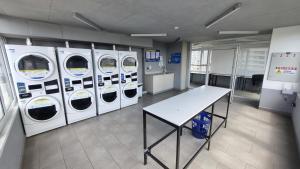 a laundry room with four washing machines and a table at Departamento Studio en pleno centro de Concepción in Concepción