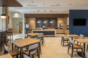 a restaurant with tables and chairs and a kitchen at SpringHill Suites by Marriott Canfield in Canfield