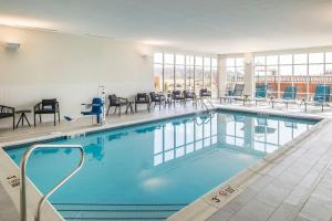 a swimming pool with chairs and tables in a building at SpringHill Suites by Marriott Canfield in Canfield