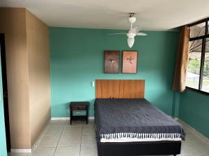 a bedroom with a bed and a blue wall at Kitnet Aurora in Miguel Pereira