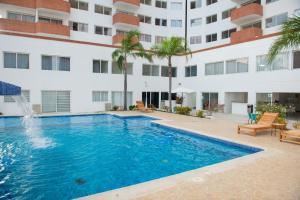 a swimming pool in front of a building at Amplio, cómodo y cerca Del Mar in Porlamar