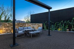 a patio with a table and chairs and a stone wall at Philoxenia Stone Suites in Choulou