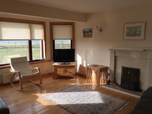 a living room with a television and a fireplace at Holiday Home Croft46 in Clachan