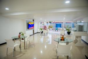 a lobby with two tables and white chairs at Amplio, cómodo y cerca Del Mar in Porlamar