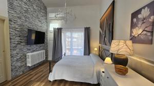 a bedroom with a bed and a brick wall at Chiantirooms Guesthouse in Greve in Chianti