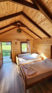 a bedroom with two beds in a wooden cabin at Villas Jezerca in Valbonë +69 photos