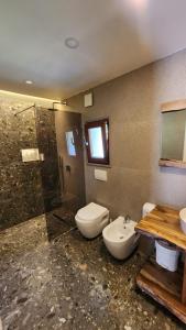 a bathroom with a toilet and a sink and a shower at Villas Jezerca in Valbonë
