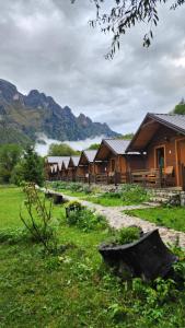 a row of lodges with mountains in the background at Villas Jezerca in Valbonë