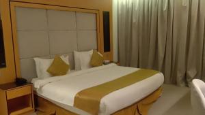 a bedroom with a large white bed with yellow pillows at فندق الريان Ryan Hotel in Jeddah