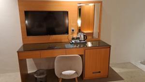 a desk with a television and a chair in a room at فندق الريان Ryan Hotel in Jeddah