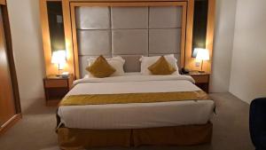a large bed in a hotel room with two lamps at فندق الريان Ryan Hotel in Jeddah