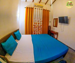 a bedroom with a bed with blue and orange curtains at natura villa in Dickwella