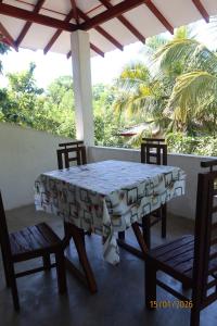 a table and chairs on a porch with a table cloth at natura villa in Dickwella