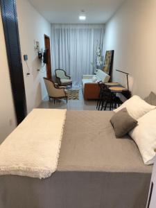 a bedroom with a bed and a living room at Loft 101 in Rio de Janeiro