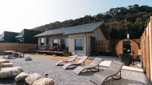 a patio with a group of chairs and a house at SAKURA YAKUSHIMA in Yakushima