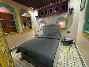 a bedroom with a bed in a room with windows at Riad Razoli Sidi Fateh in Rabat