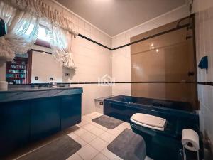 a bathroom with a toilet and a sink at Casa Flora Garden & Pool in Carapicuíba +28 photos
