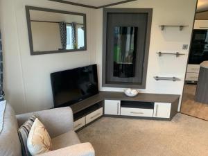 a living room with a flat screen tv on a wall at Lily's caravan in Meliden