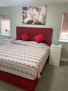 a bedroom with a red bed with red pillows at Cozy Private Room & Breakfast Dublin 15 in Tyrrelstown