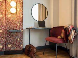 a room with a desk with a chair and a mirror at Ibis Styles Madrid Centro Maravillas in Madrid