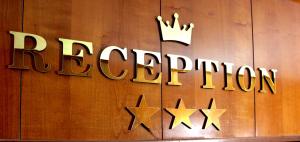 a sign for a restaurant with a crown on a wooden wall at Hotel Fiorella Milano in Milan