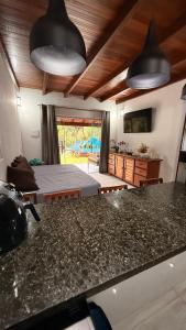 a bedroom with a bed and a kitchen with a counter top at Casa.dovale3 in Caeté-Açu
