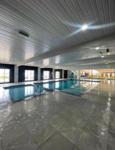 an empty swimming pool in a large building at Lily's caravan in Meliden +3 photos