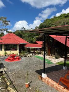 a building with a red roof and a patio at Aire Agua y Naturaleza in Guácimo