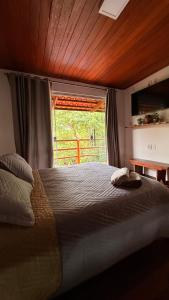 a bedroom with a large bed with a window at Casa.dovale3 in Caeté-Açu +9 photos