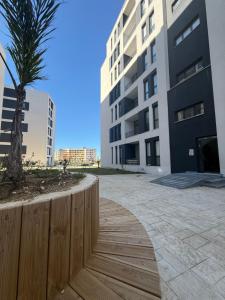 a wooden walkway next to a building with a palm tree at Marelia in Orikum