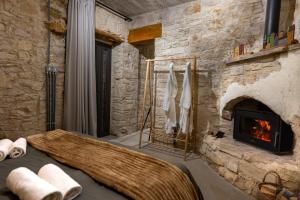 a living room with a stone wall with a fireplace at Philoxenia Stone Suites in Choulou +37 photos