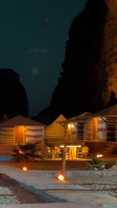 a building with a table and chairs at night at Rum Arena camp in Wadi Rum