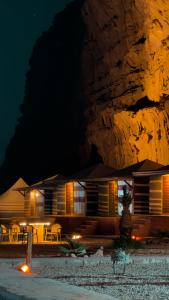 a building with a mountain in the background at night at Rum Arena camp in Wadi Rum
