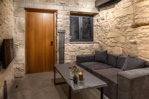a living room with a couch and a table at Philoxenia Stone Suites in Choulou