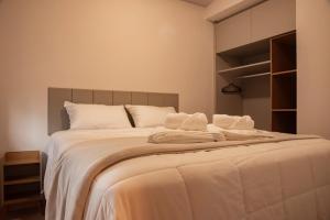 a bedroom with a large bed with white sheets and pillows at Essential 2U in São Paulo
