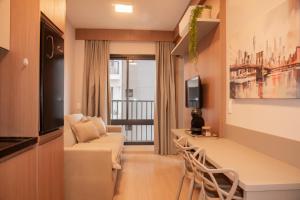 a living room with a couch and a tv at Essential 2U in São Paulo