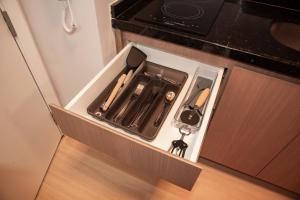 a drawer in a kitchen with utensils in it at Essential 2U in São Paulo